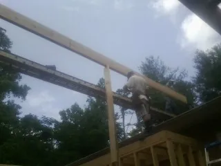 Carpenter setting a ridge beam over a new addition frame — Ice Dam Removal by Roofing Brothers in Johns Island