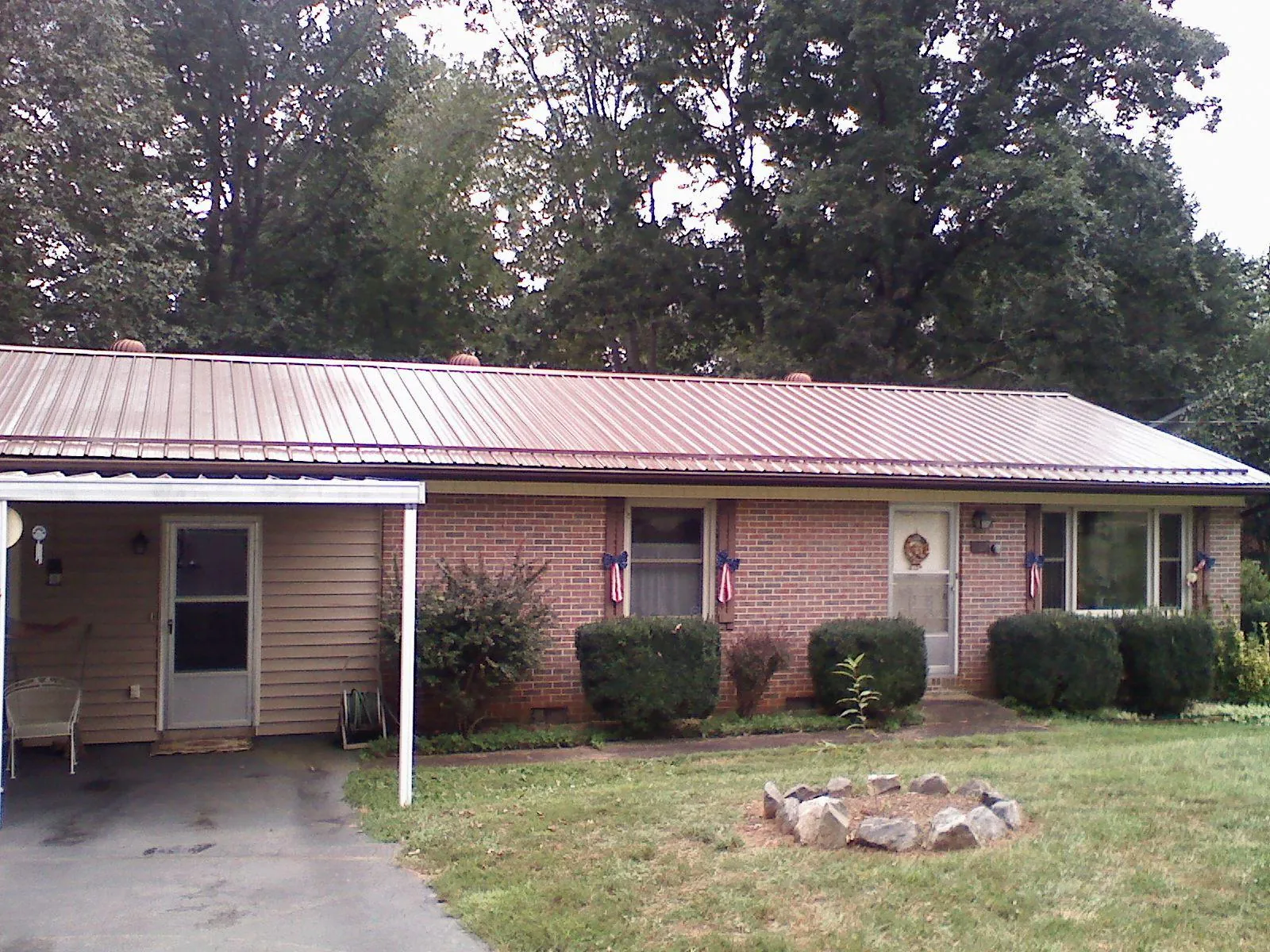 Bronze metal roof and carport on a brick ranch home — Roof Repair work by our crew in Johns Island